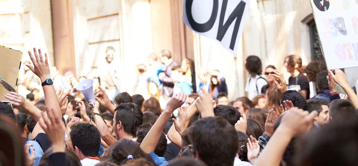 A large group of people rallying in streets with signs and megaphones